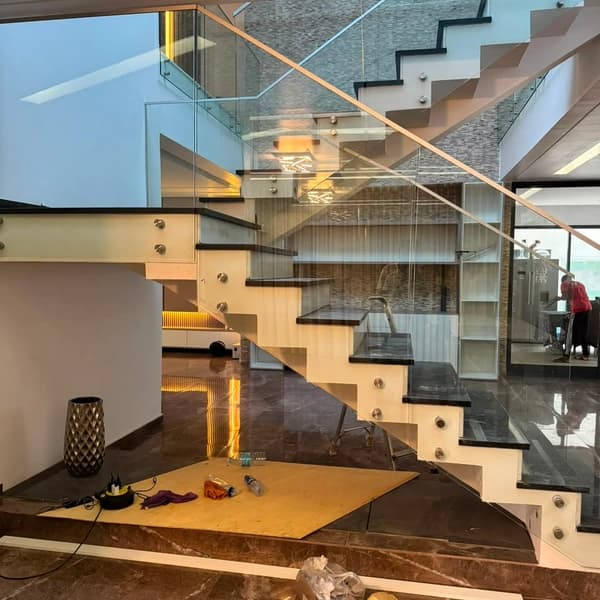 Escada com guarda em vidro e caixilharia em alumínio numa moradia.